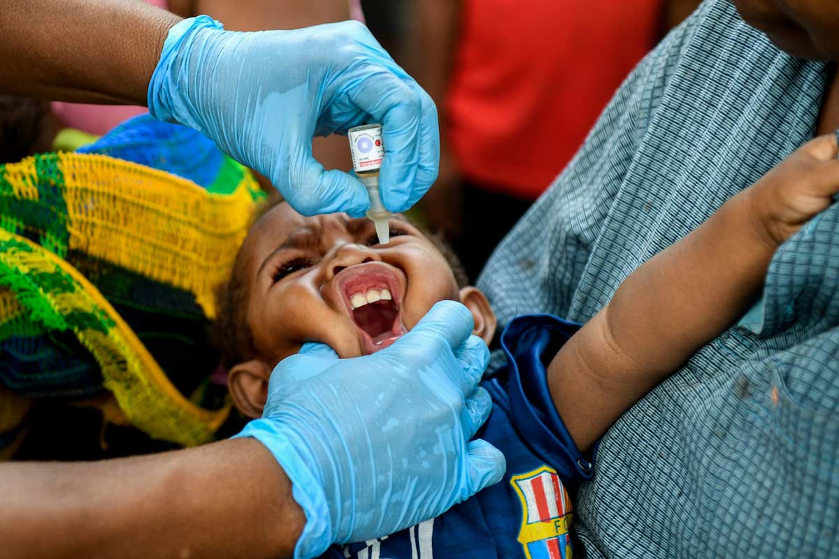 A child in Papua New Guinea receiving an oral polio vaccination during a previous outbreak in 2018. Brendan Esposito/AAP